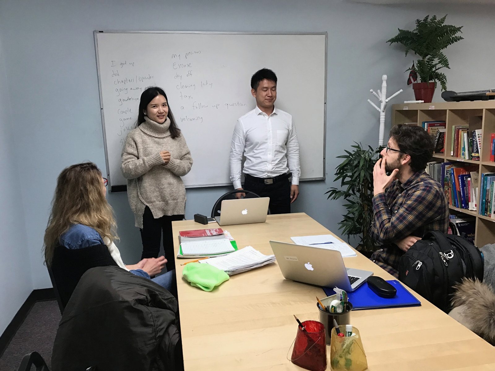 Students presenting to a small group around a classroom table